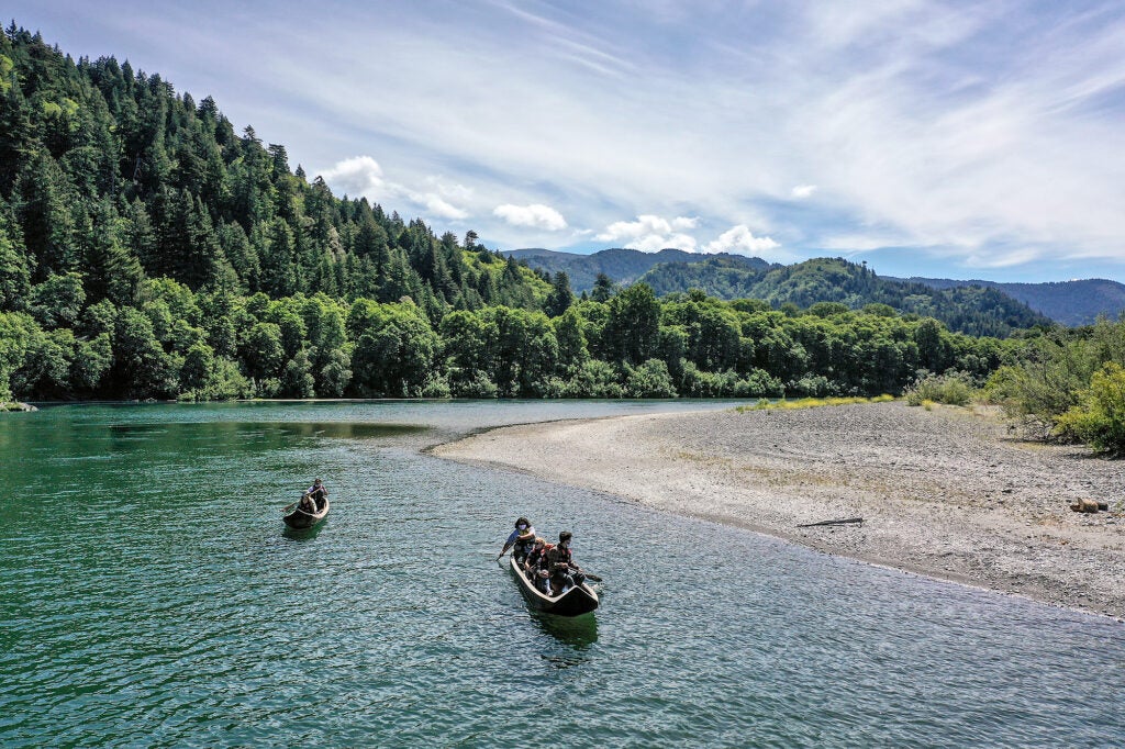 Yurok guides paddle tourists along the Klamath River in traditional canoes hand crafted from Redwood trees. (Robert Gauthier / Los Angeles Times via Getty Images)