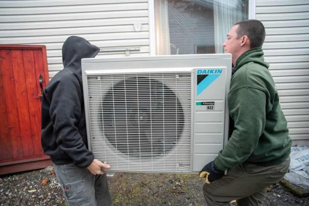 Sonny Ashby, (izq.), y Robby Brian (der.), de Alaska Plumbing and Heating, instalan una bomba de calor en Juneau, Alaska.