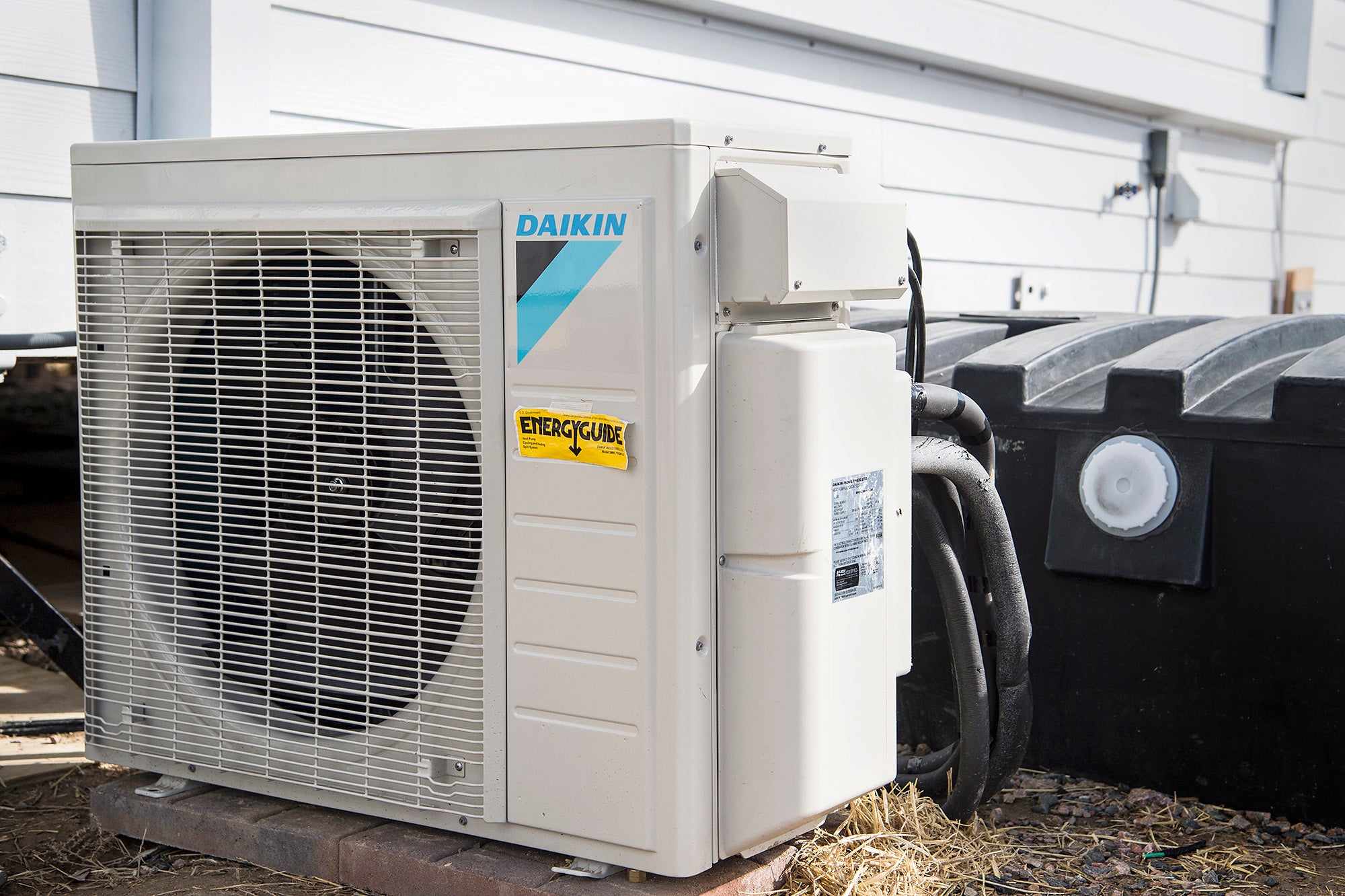 A metal box with a fan inside and hoses coming out.