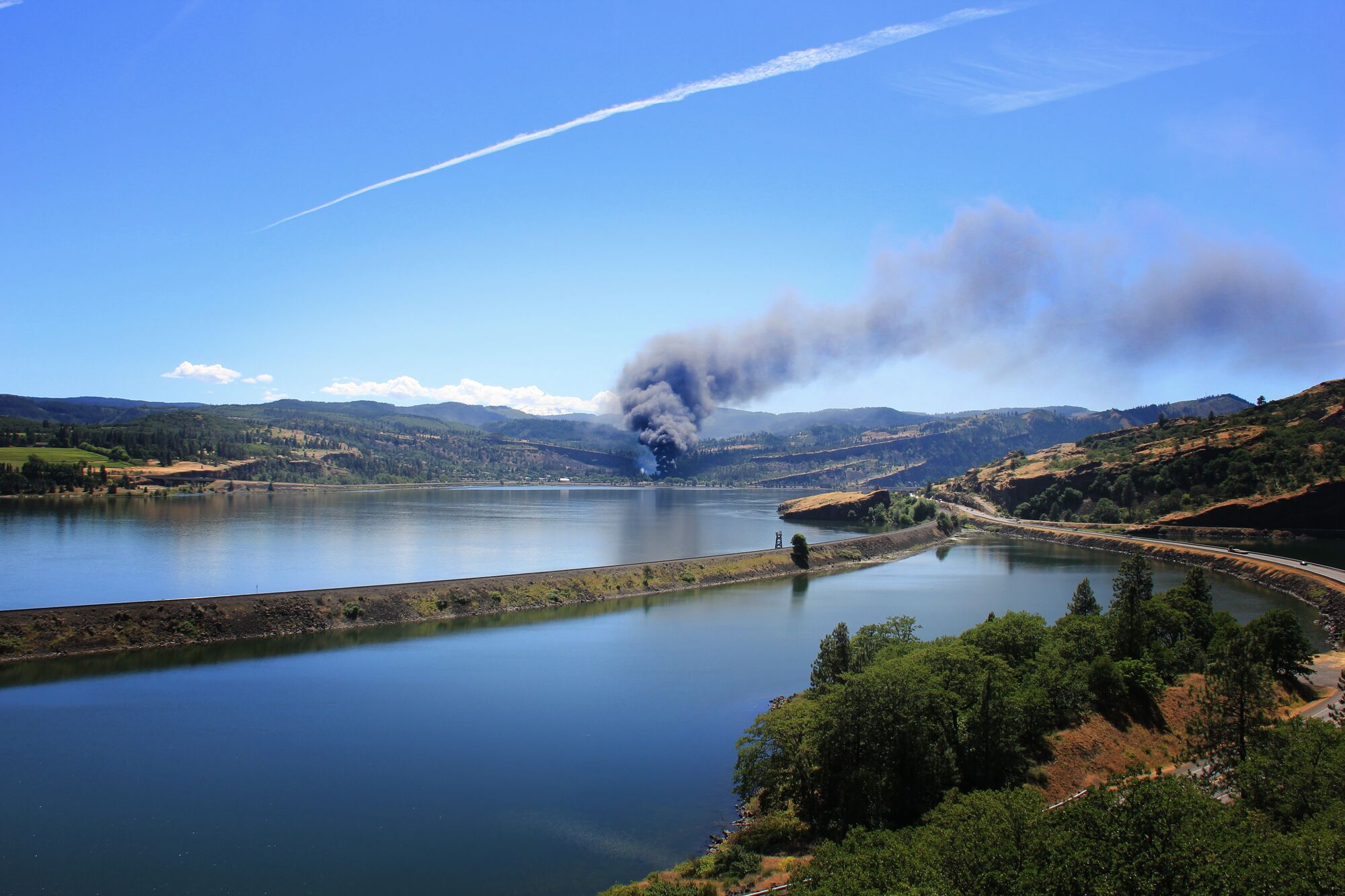 A Union Pacific oil train carrying crude oil to the Port of Tacoma, Washington derailed in the town of Mosier, Oregon on June 3, 2016. ..A black plume of smoke can be seen miles away, and a limited amount of oil did spill into the Columbia River despite efforts to contain it. The residents of the town were ordered to evacuate for their safety as crews cleaned up the derailment. (Ray Wan for Earthjustice)