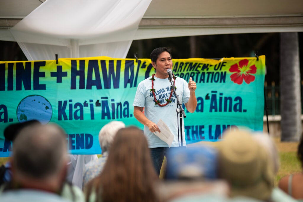 Earthjustice attorney Isaac Moriwake speaks at the Navahine + Hawai’i Department of Transportation youth climate settlement celebration at ‘Iolani Palace on June 24th, 2024. (Elyse Butler for Earthjustice)