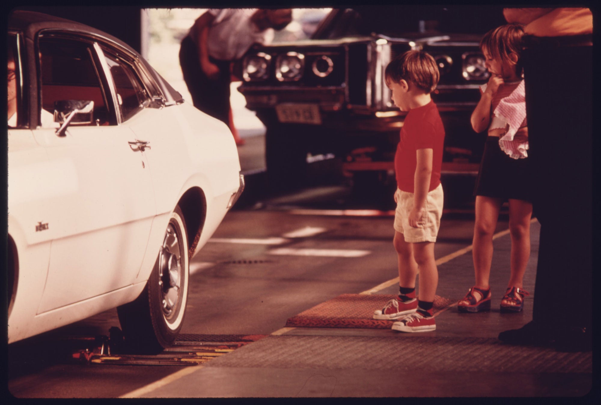 Children watch as their car is tested at an auto emission inspection station in downtown Cincinnati, Ohio.