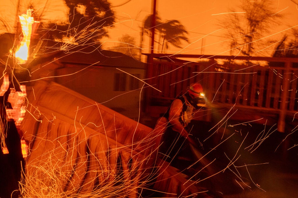 Strong winds blow embers around firefighters battling to save homes in Pasadena, Calif., from the Eaton Fire on Jan. 7, 2025. (David McNew / Getty Images)