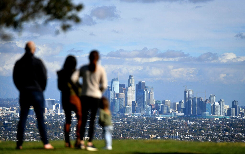 People enjoy a sunny afternoon in a Los Angeles park with a view of the downtown skyline. (Chris Delmas / AFP via Getty Images) 