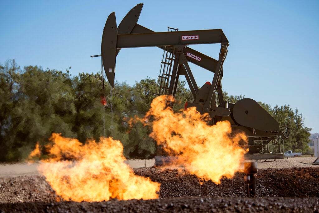 Flaring natural gas burns by jack pumps at an oil well near Buford, North Dakota in the Bakken oil fields. (William Campbell / Corbis via Getty Images)