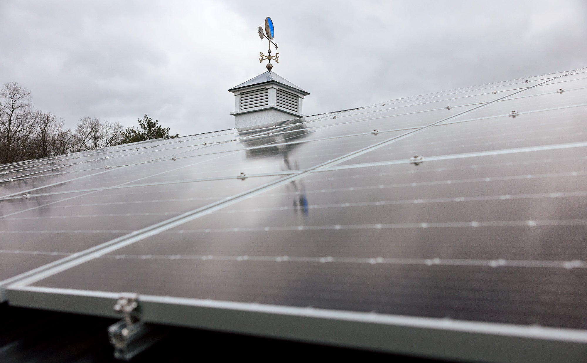 Solar panels on the roof of a bar with a cupola and weather vane on top.