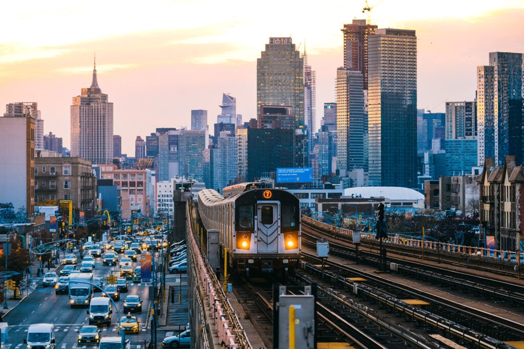 A subway train on the 7 line in Queens, with New York City's Manhattan skyline in the background.