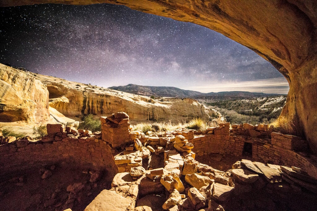 Looking out from an ancient cliff dwelling to the night sky filled with stars.