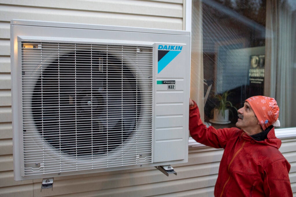 Andy Romanoff. Executive Director of Alaska Heat Smart, looks at a heat pump being installed at a home in Juneau, Alaska. (Michael Penn for Earthjustice)