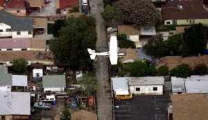 Aerial view of a residential area. A low flying air craft above houses.