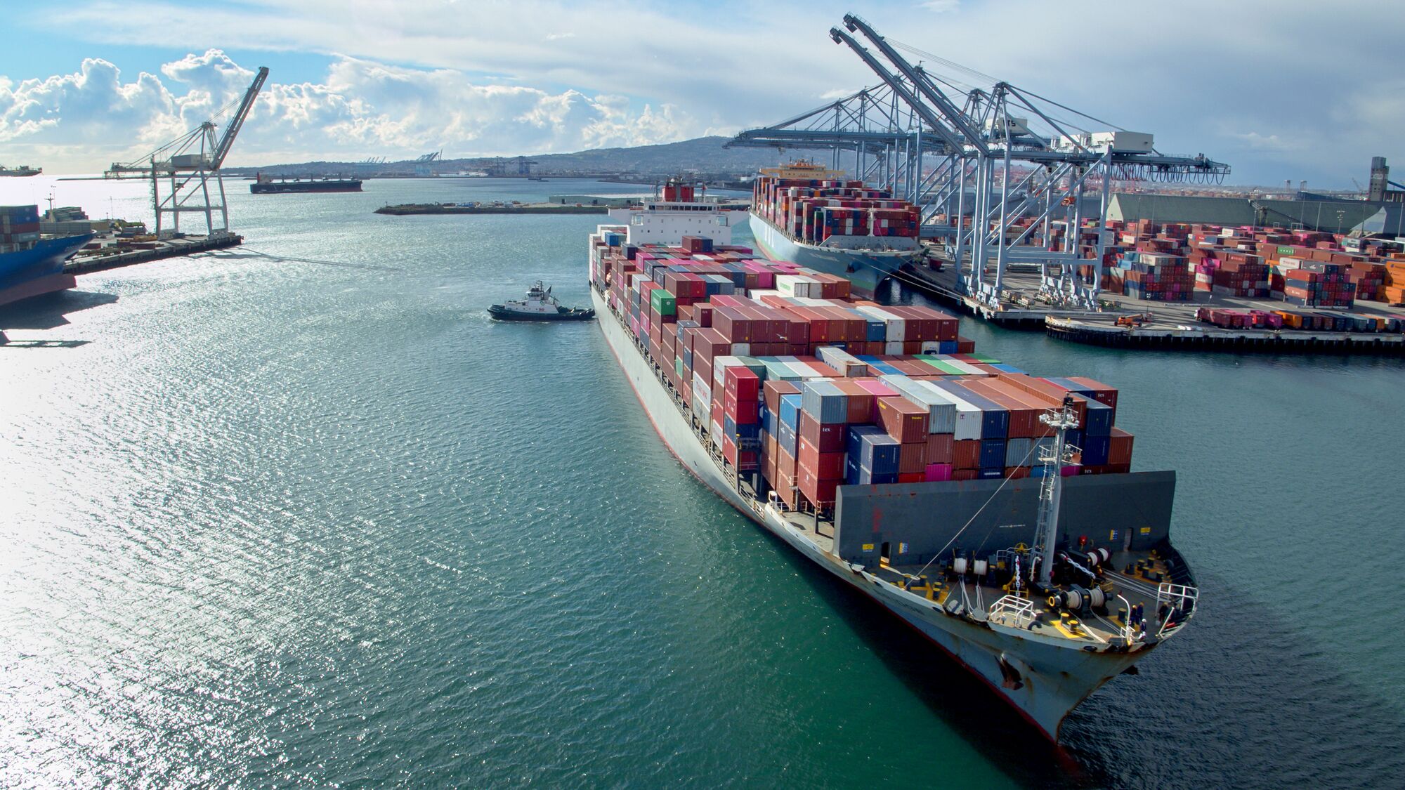 Drone shot of a massive container ship arriving in the Port of Long Beach, California.