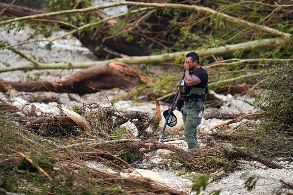 A sheriff's deputy pauses while combing through the banks of the Guadalupe River after a flash flood swept through the area in July 2025. (Julio Cortez / AP)