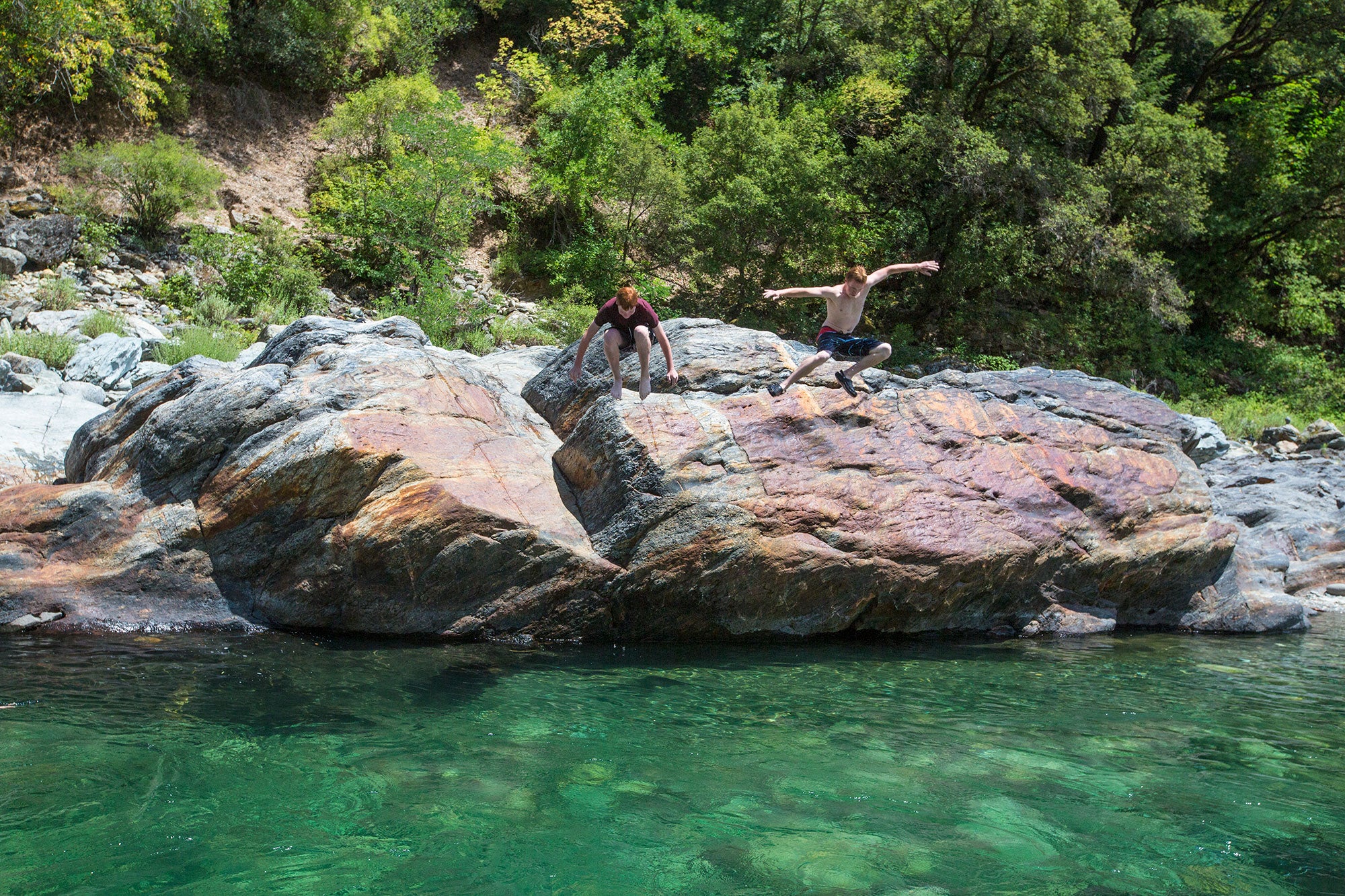North Fork of the American River Two young swimmers leap from a large boulder into the pristine waters of the North Fork of the American River.