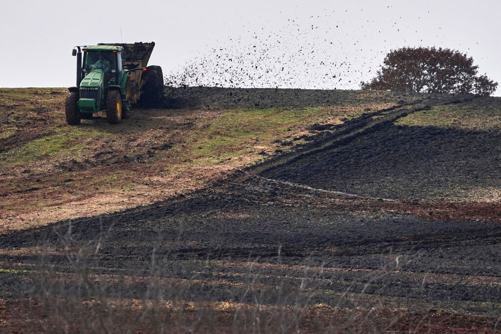 A spreader applies sewage sludge to a farm field in Wellston, Okla. (Joshua A. Bickel / AP)