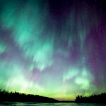 An aurora lights up the starry night sky in the Boundary Waters Canoe Area.