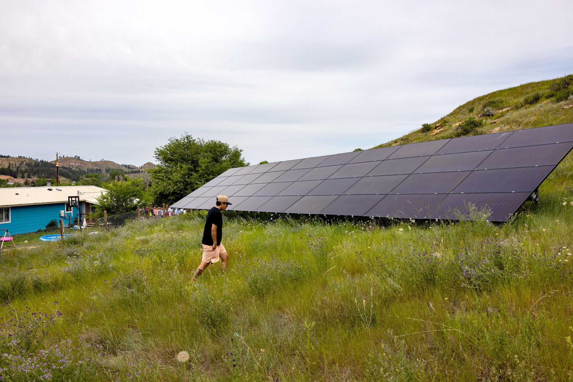 Charlee Rising Sun walks to a solar mount on the Northern Cheyenne Reservation.