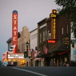 Brightly lit storefronts in downtown Ely, Minnesota, in the early hours of the evening.