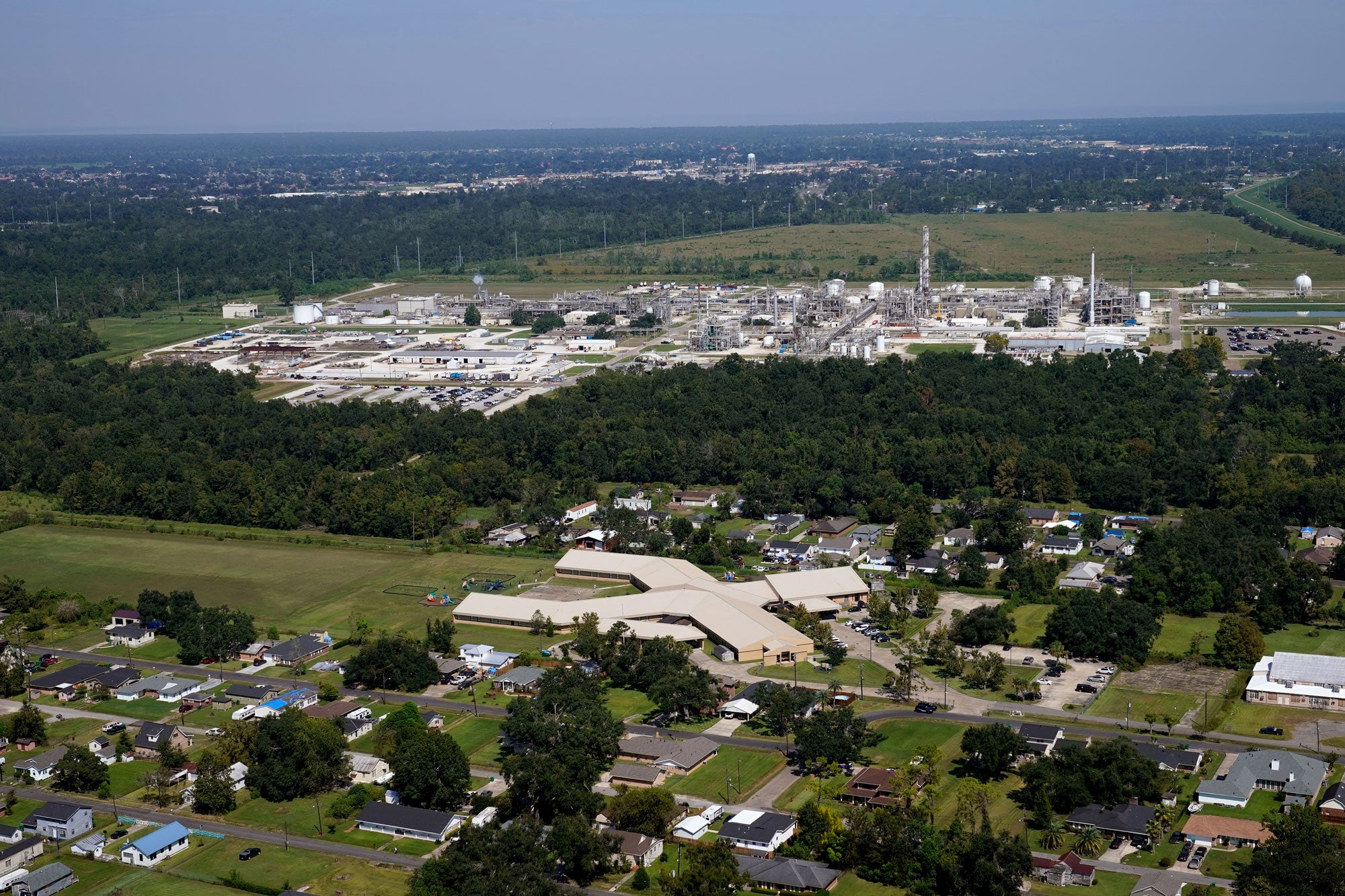 Aerial view of a neoprene manufacturing facility near homes and a school.