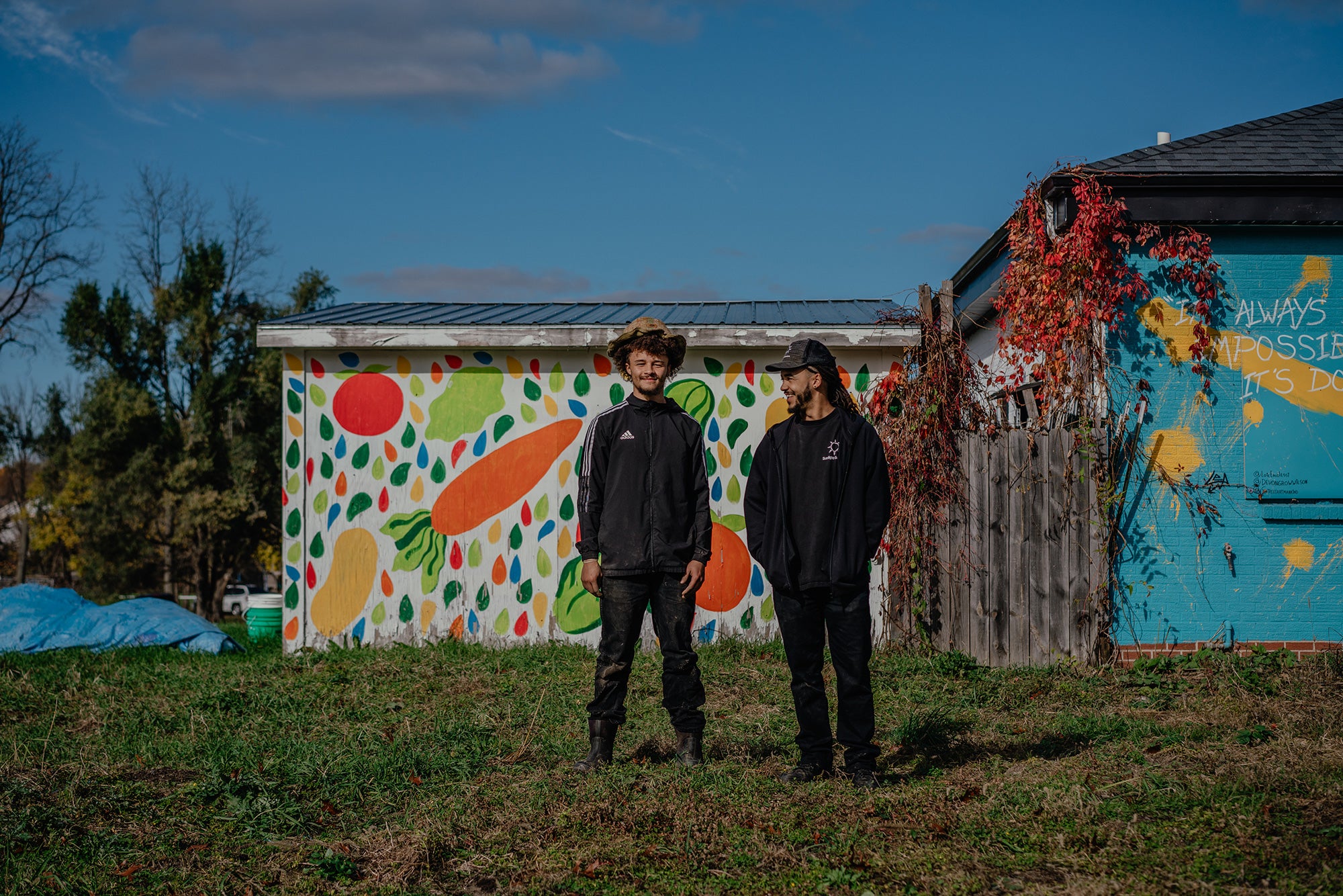 Sunlight Gardens Jerry Olds, an employee of Sunlight Gardens, stands next to owner Devon Wilson on the two-acre urban farm in Battle Creek, Michigan, in front of colorfully painted buildings.