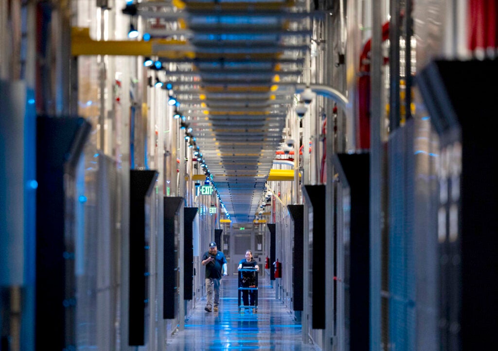 A long view down a hallway surrounded by exposed server racks