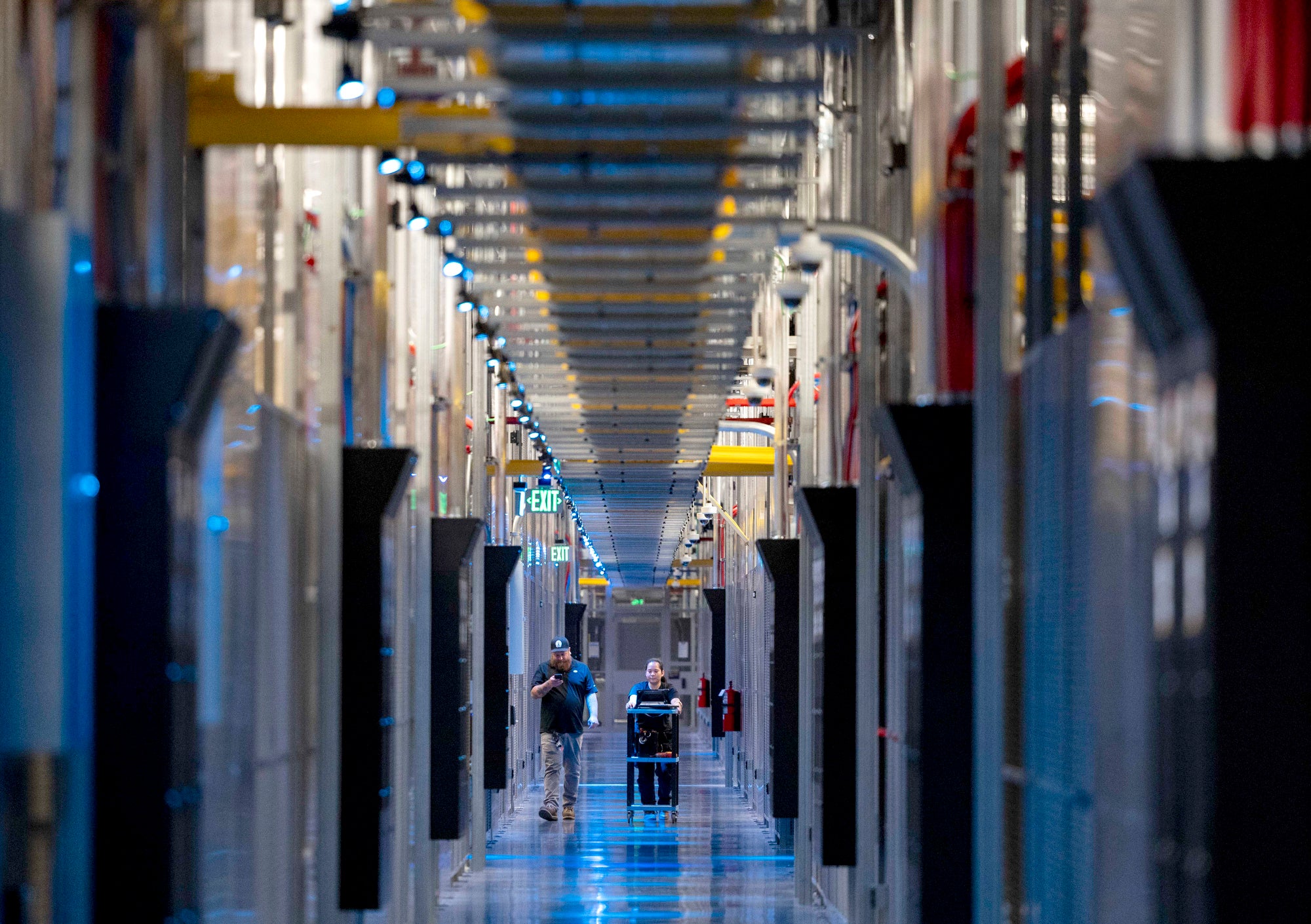 A long view down a hallway surrounded by exposed server racks