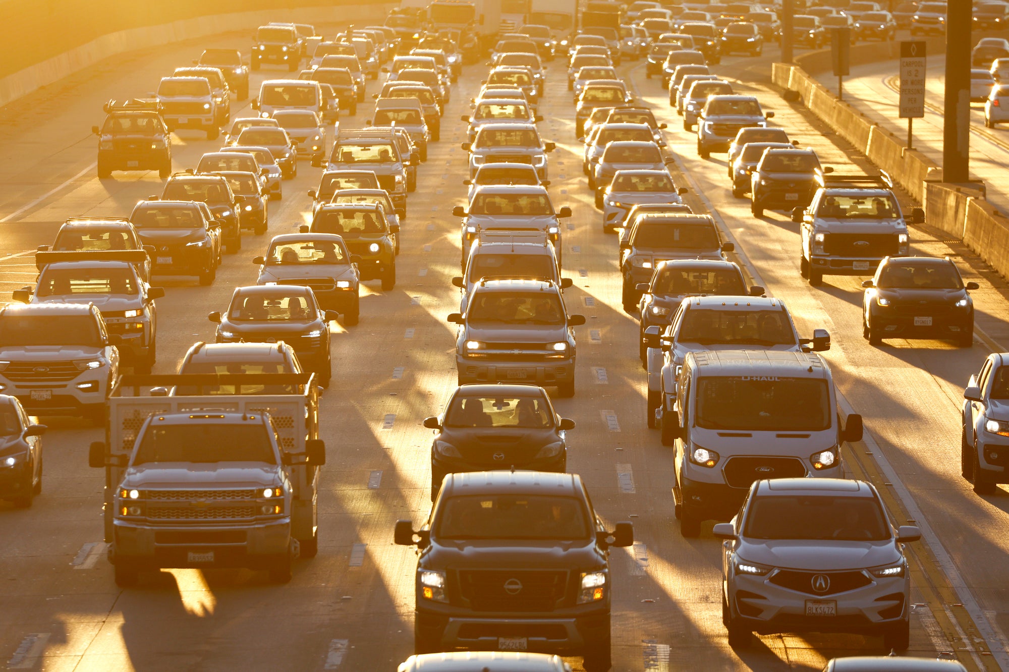 A freeway full of cars in morning sunlight.