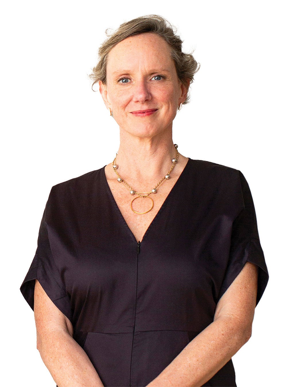 Abigail stands facing the viewer with an open, friendly expression, wearing a black dress and her hands clasped in front of her.