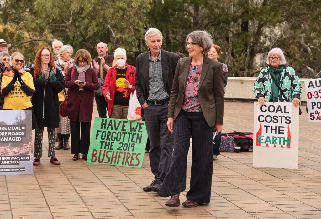 Tony Lonergan and Wendy Wales, foreground, speak at a rally outside the High Court of Australia in Canaberra during their legal effort to protect their community from the expansion of the Mount Pleasant coal mine. (Zoe Lonergan)