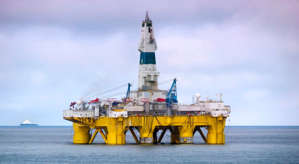 A drilling platform sits in a large body of water.