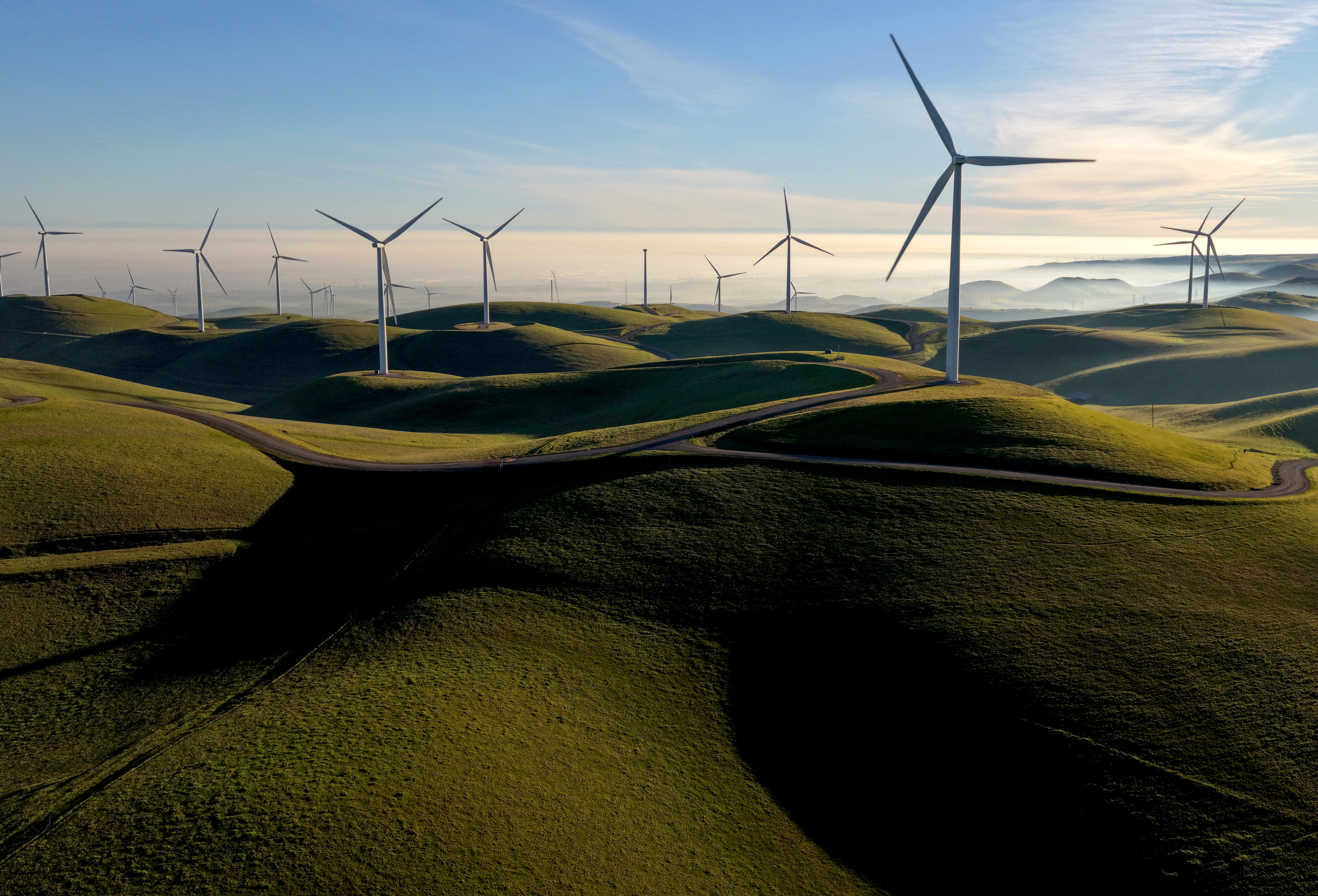 Wind turbines on a hilly field.