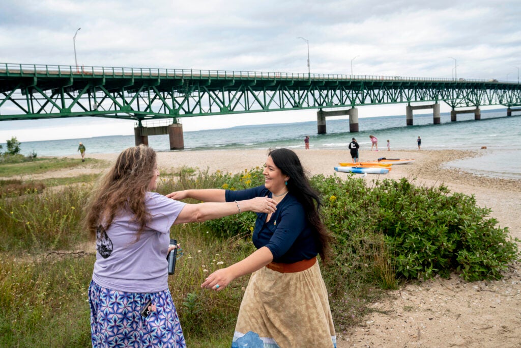 Bay Mills Indian Community  President Whitney Gravelle, right, greets supporters at the Pipe Out Paddle Up Flotilla Against the Line 5 pipeline in Mackinaw City, Michigan in 2022. (Sarah Rice for Earthjustice)