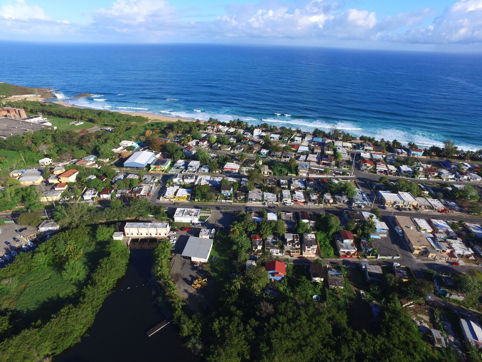 An aerial view of homes and the blue ocean in Arecibo, Puerto Rico.