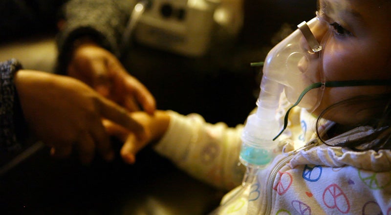 A mother comforts a child receiving treatment for asthma in Southern California.