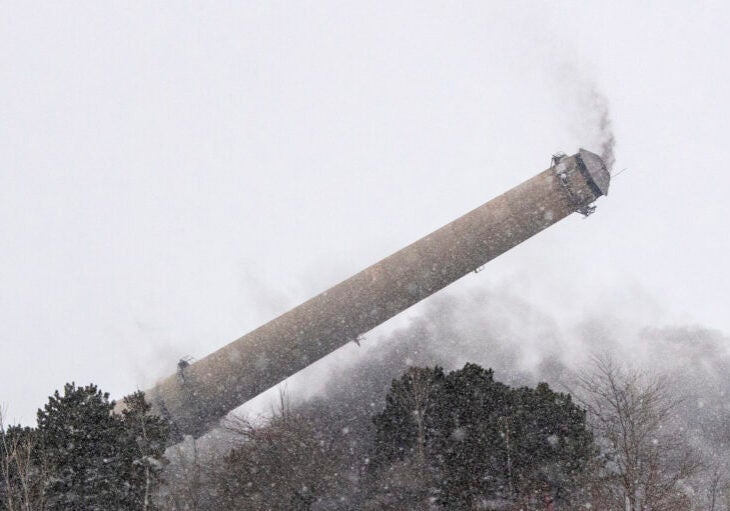 A smoke tower falls to the ground during a snow storm