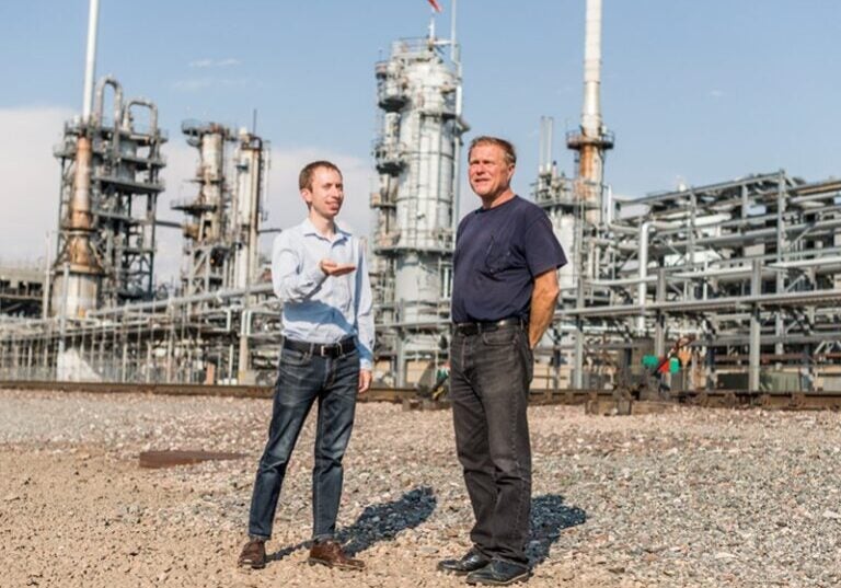 El abogado de Earthjustice Joel Minor (izquierda) habla con Drew Dutcher (derecha), un residente de Denver que tiene que compartir su comunidad con la refinería Suncor.