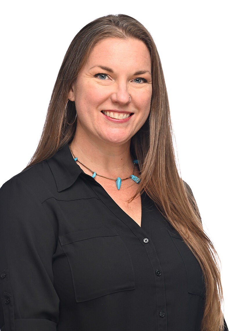 Bonnie looks directly at the viewer with a friendly, open smile. She's wearing a black button-down top and is in front of a white backdrop.