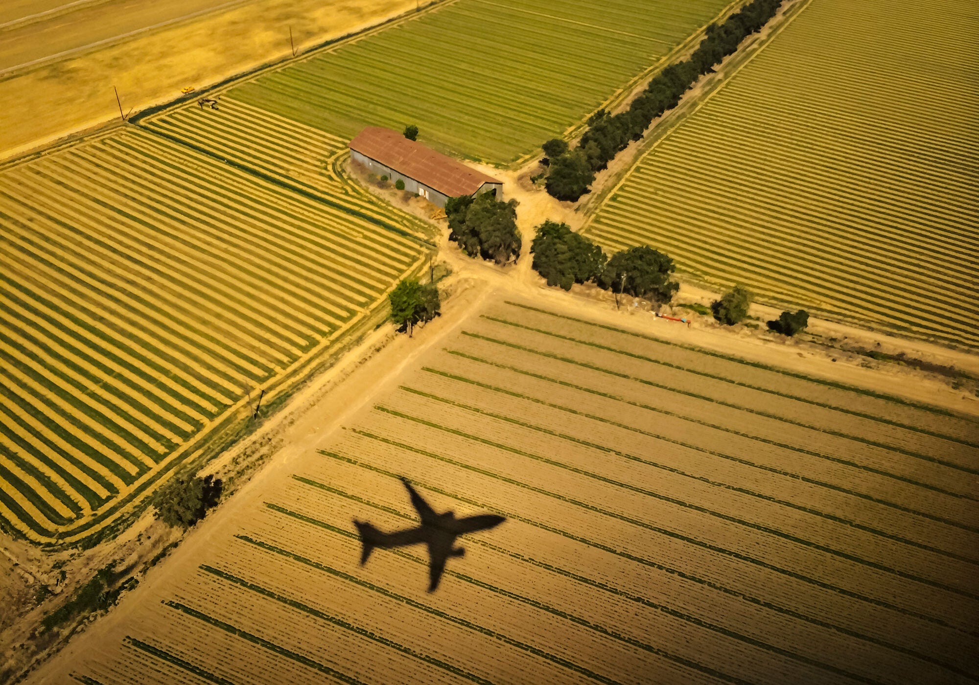 Airplane Above Farm Fields Aerial view of a airliner's shadow on agricultural farm fields as it approaches an airport for its landing.