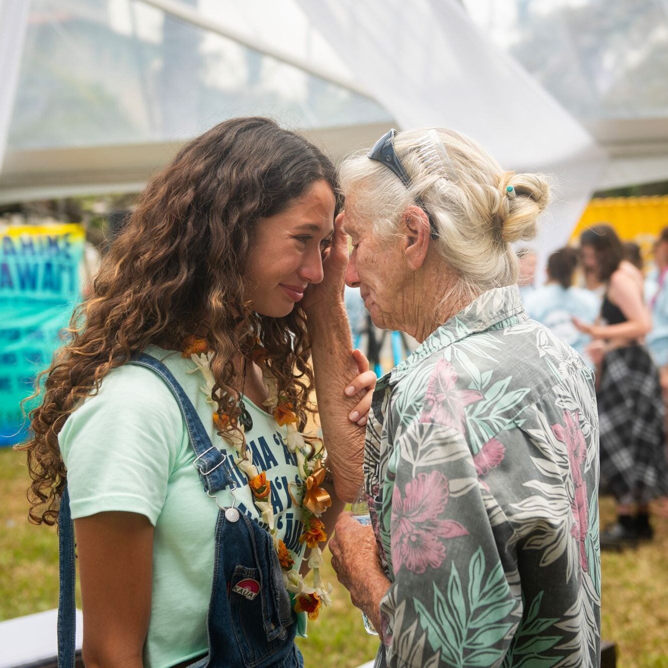 Youth plaintiff Kalā W. shares a moment with an elder after the announcement of the groundbreaking settlement agreement in the Navahine v. Hawai’i Department of Transportation lawsuit.