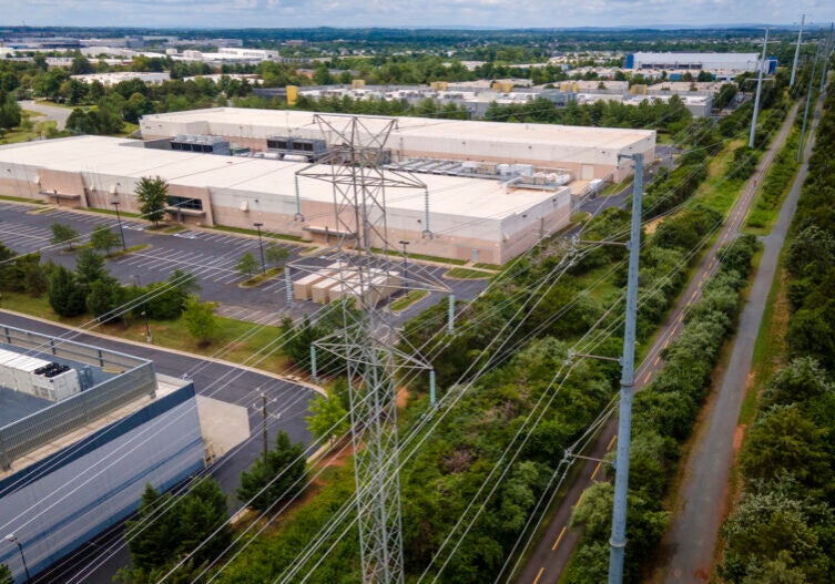 An aerial photo of large buildings with power lines in the foreground