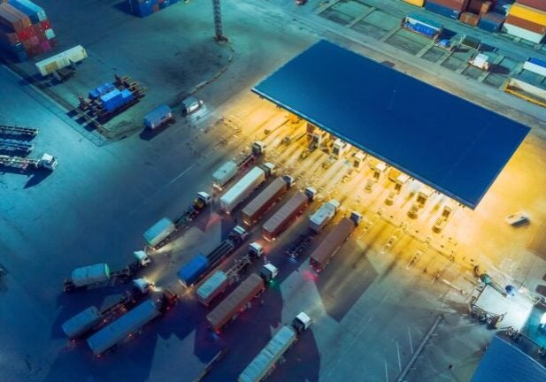 Aerial view container truck waiting at check point or terminal for unload container at container warehouse for logistics, import export, shipping or transportation. (Suriyapong Thongsawang / Getty Images)