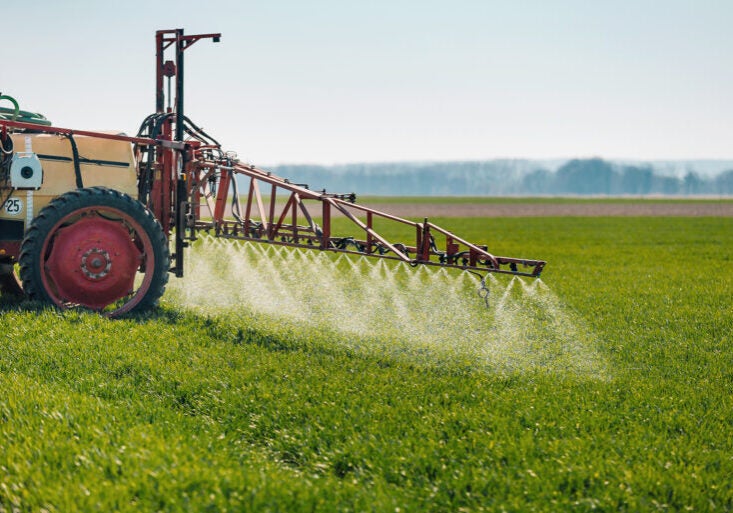 Chemicals being sprayed on a field of crops