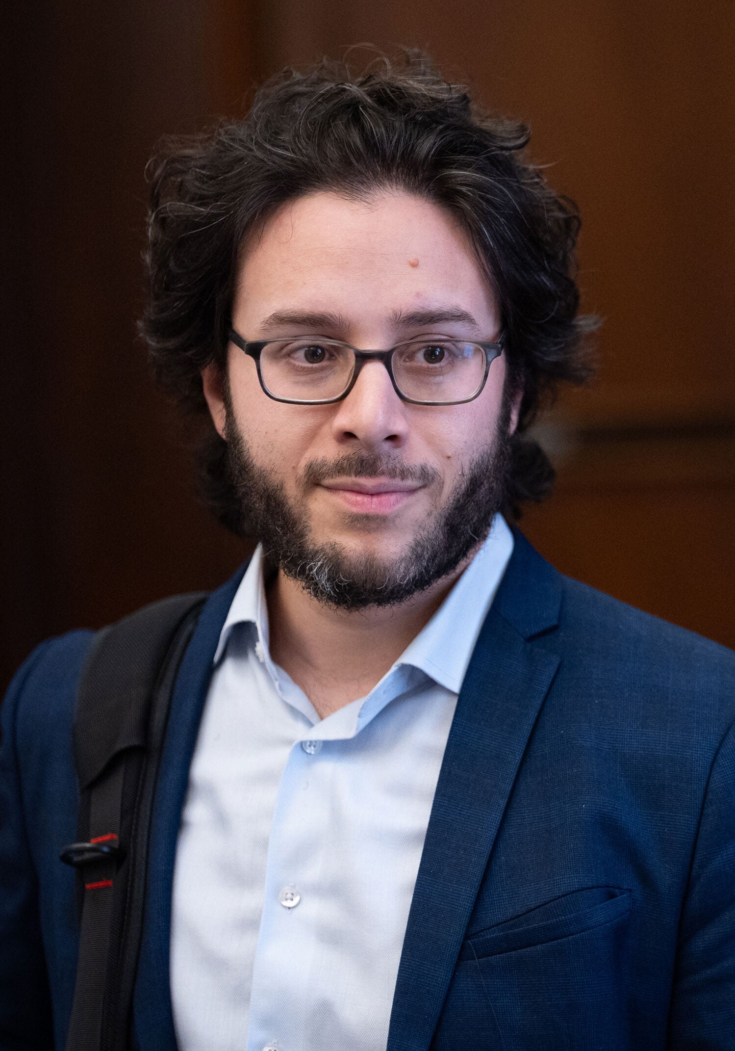Julian Gonzalez, senior legislative counsel in Earthjustice's PAL team is looking off to the side. He has a bag strap over one shoulder.