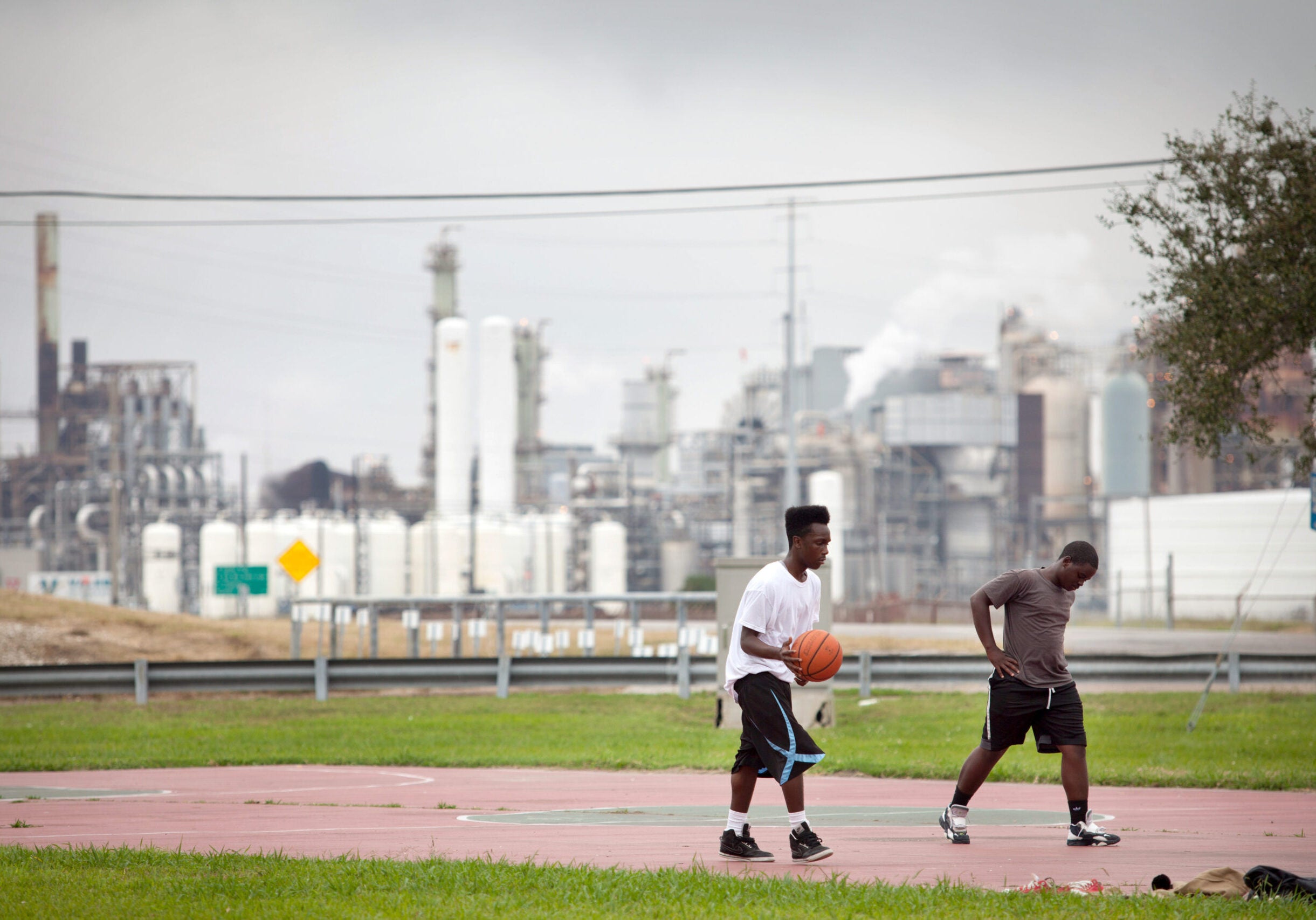 Teenagers play basketball in the Carver Terrace housing project in 2013 in Port Arthur, Tex.