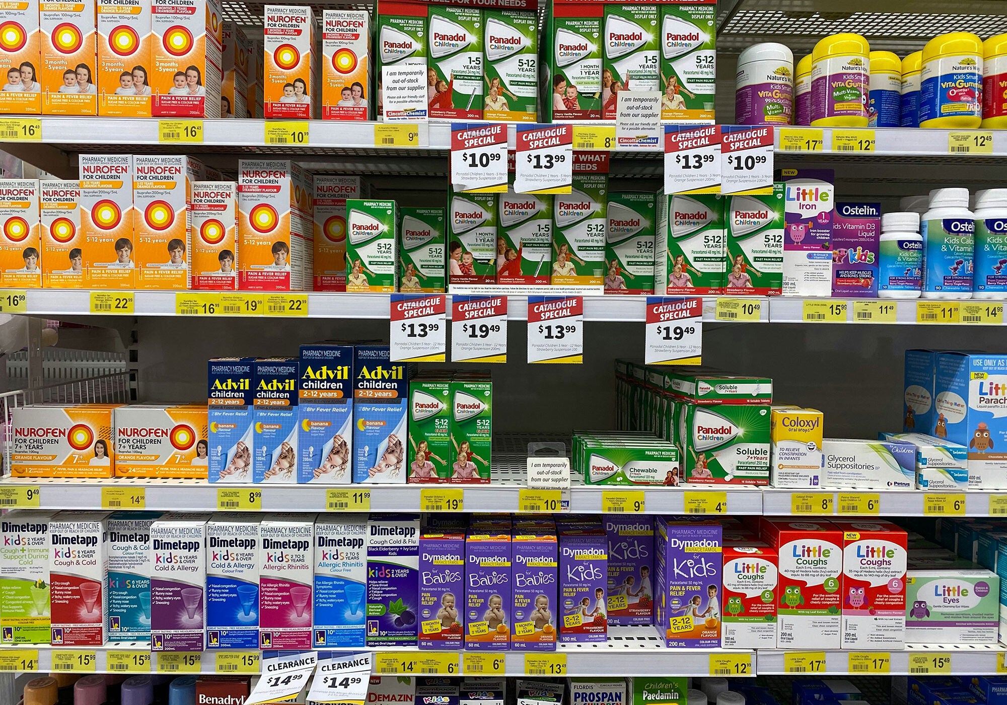 An aisle of shelves in a store filled with over-the-counter medication for fever relief, cold and flu symptoms, and more.