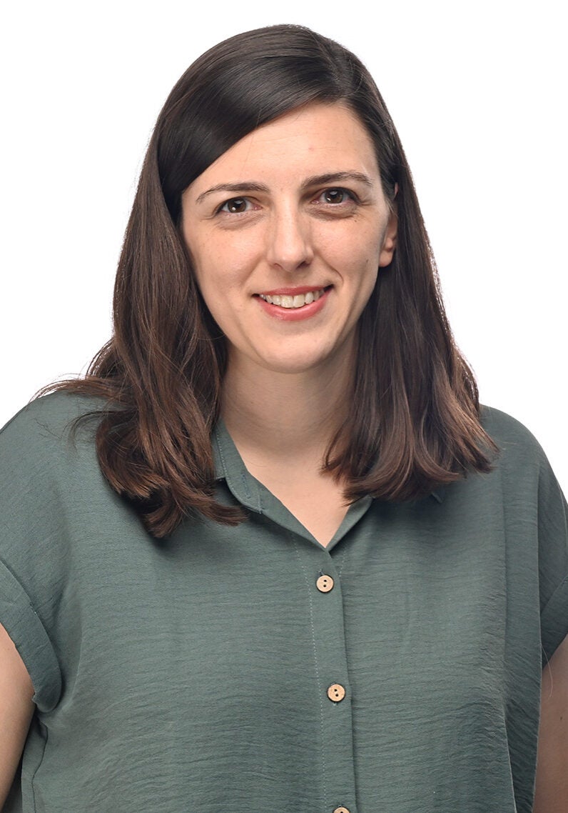 Melissa looks directly at the viewer with a friendly, open smile. She's wearing a sea-green collared, button-down blouse, and is standing in front of a white backdrop.