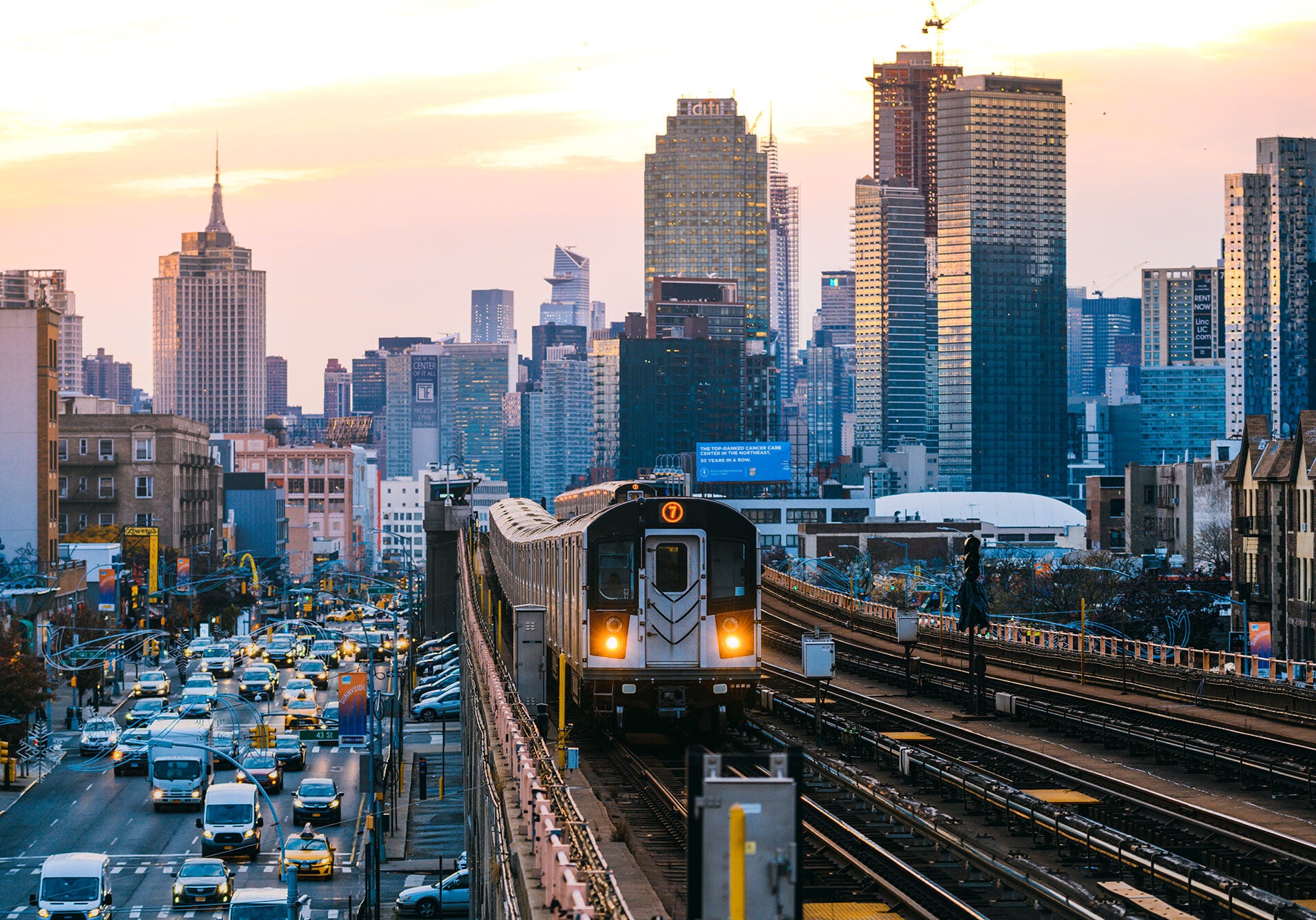 A subway train on the 7 line in Queens, with New York City's Manhattan skyline in the background.