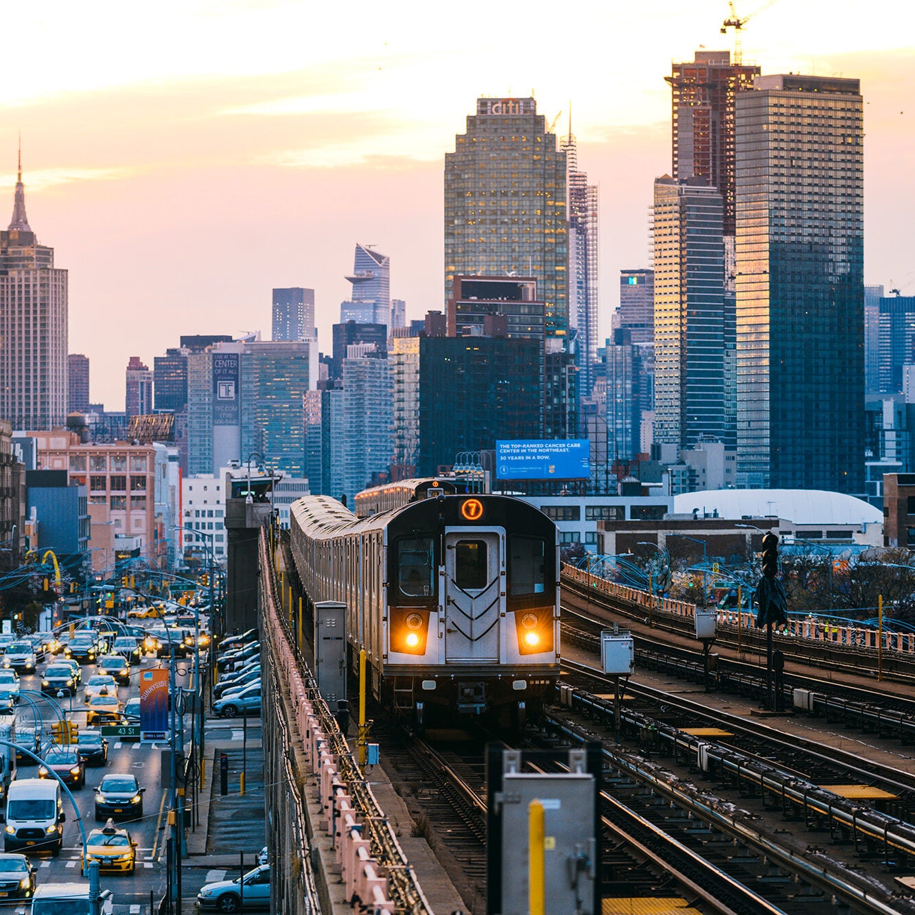 A subway train on the 7 line in Queens, with New York City's Manhattan skyline in the background.