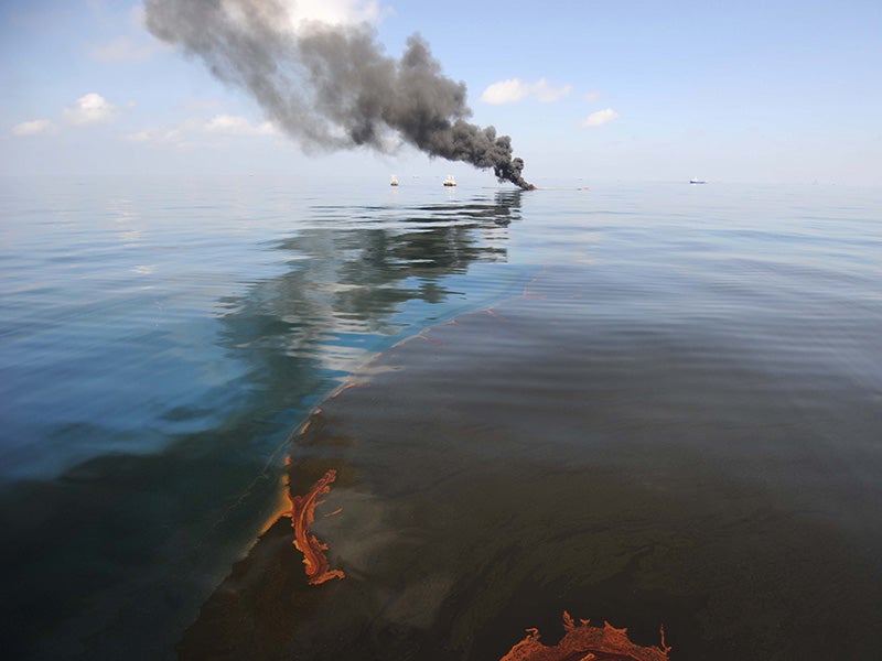 Dark clouds of smoke and fire emerge as oil burns during a controlled fire in the Gulf of Mexico following the April 20, 2010 explosion on the Deepwater Horizon.
