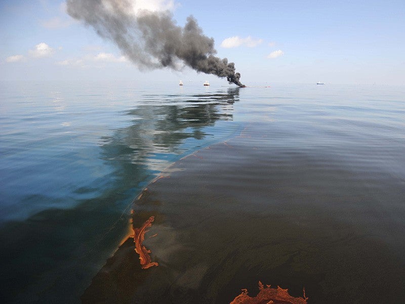 Dark clouds of smoke and fire rise from a controlled oil fire in the Gulf of Mexico following the April 20, 2010, explosion on the Deepwater Horizon.