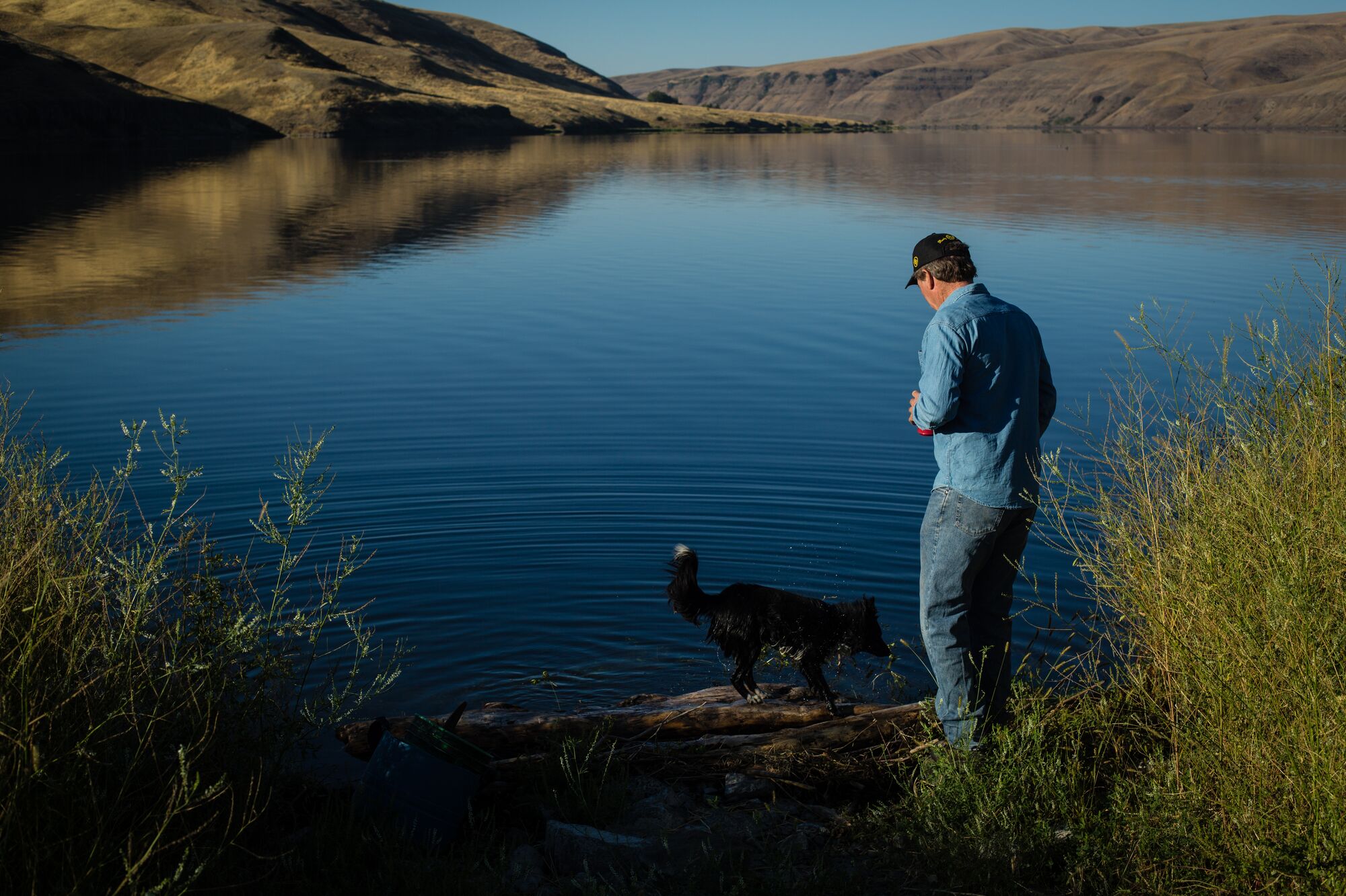 Bryan Jones, a farmer on the Paloose in eastern Washington, walks with his dog along Lake Bryan. The lake is one of a series that was created when the free flowing lower Snake River was dammed in the 1970s.